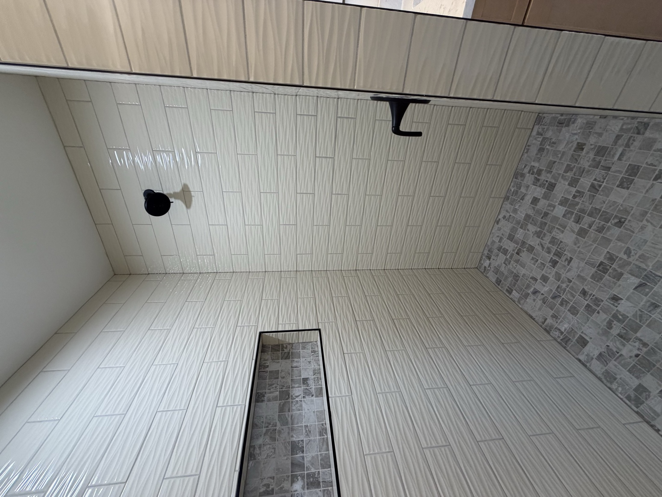 Tile shower with linear drain and vertical white subway tile