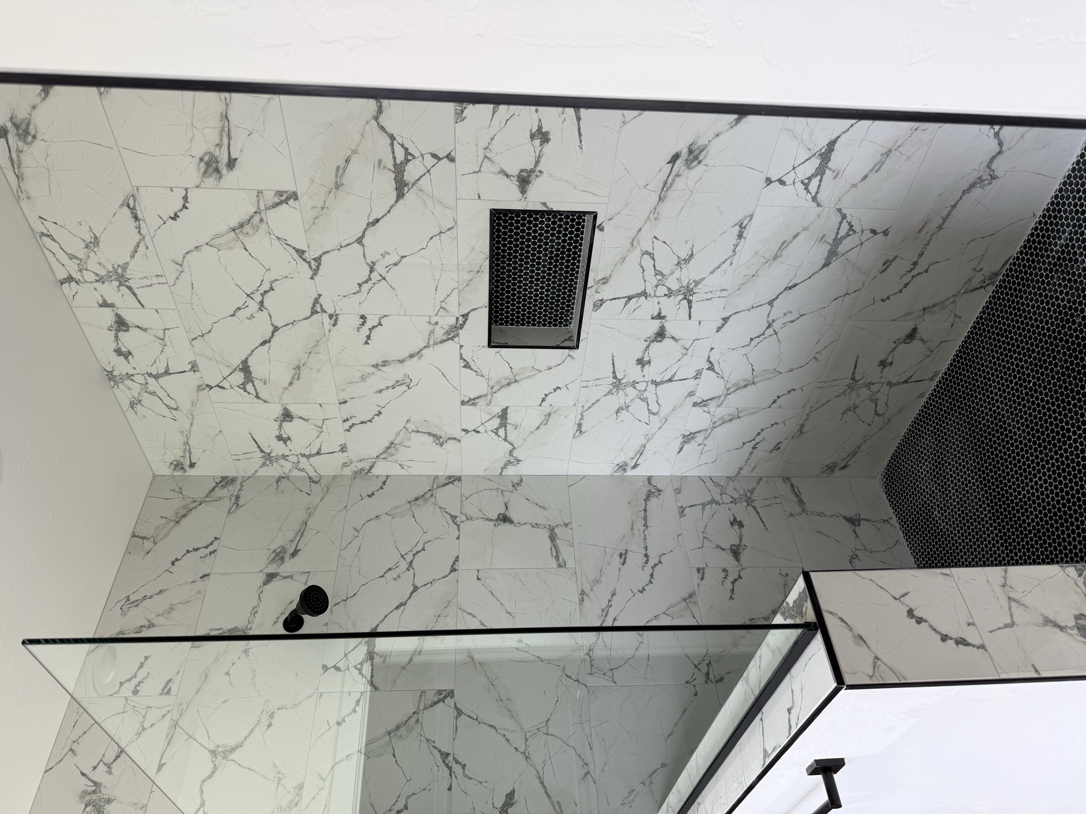 Custom shower with full slab marble walls and matte black fixtures