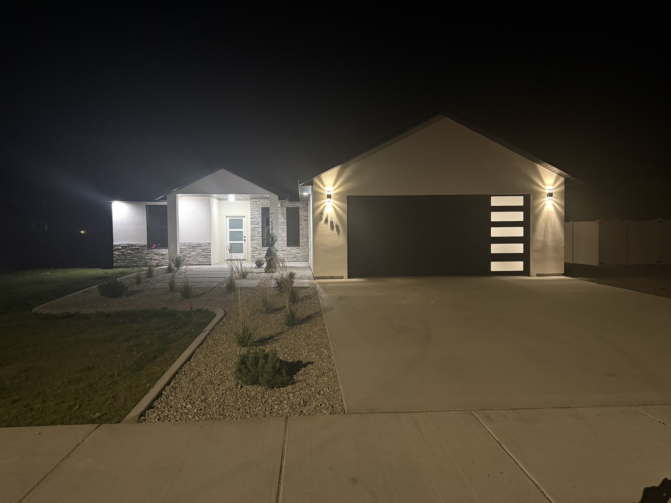 Custom Idaho home exterior at night with modern garage door