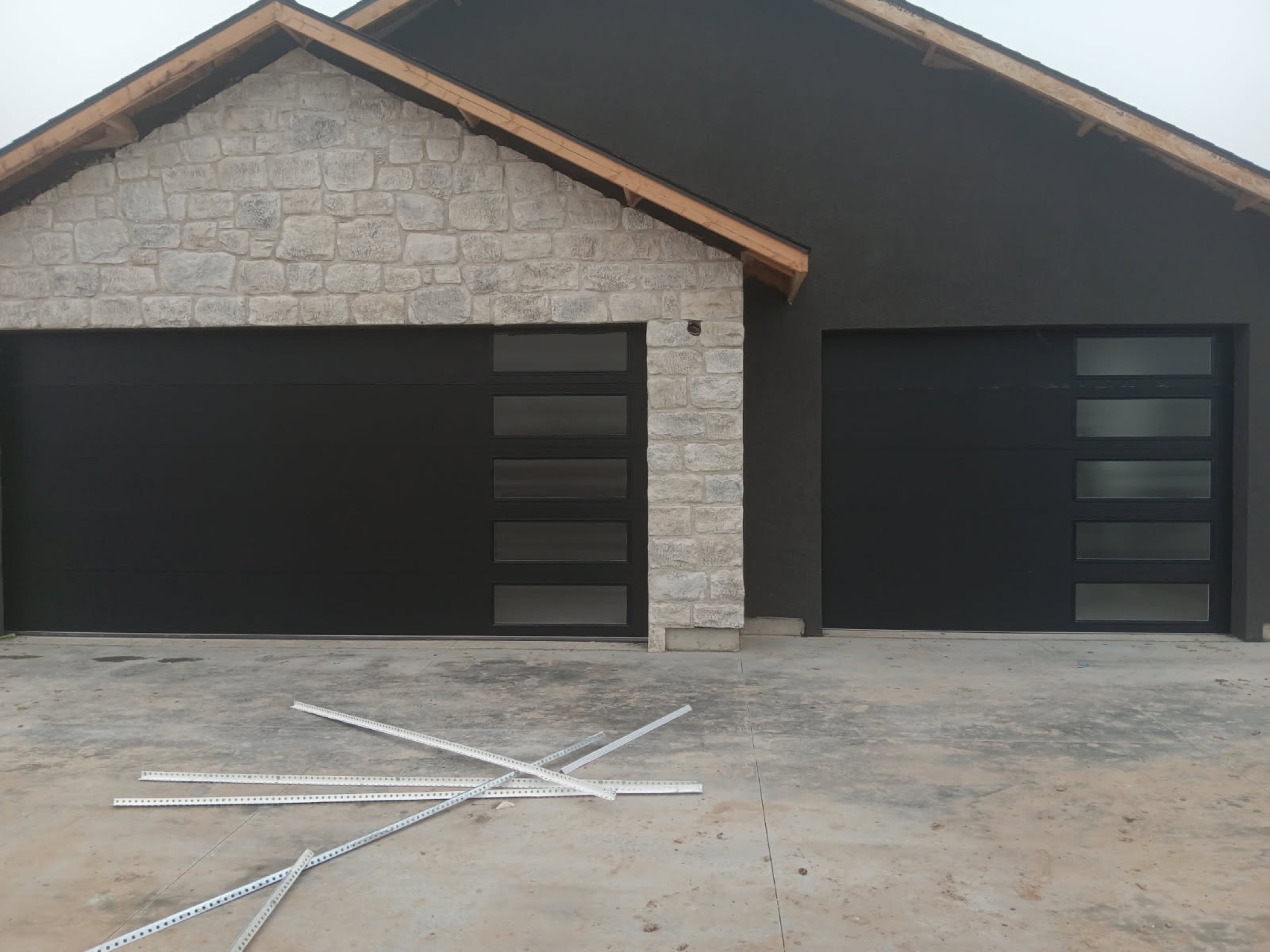 Stone-front Idaho custom home with modern black garage doors