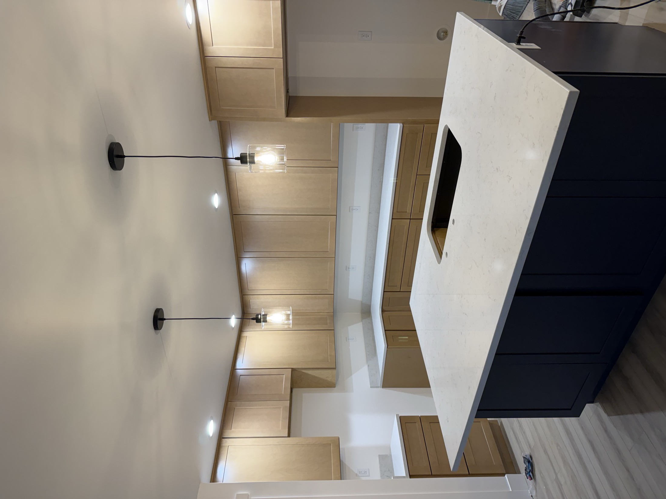 Butler's pantry with quartz counters and wall sconce lighting