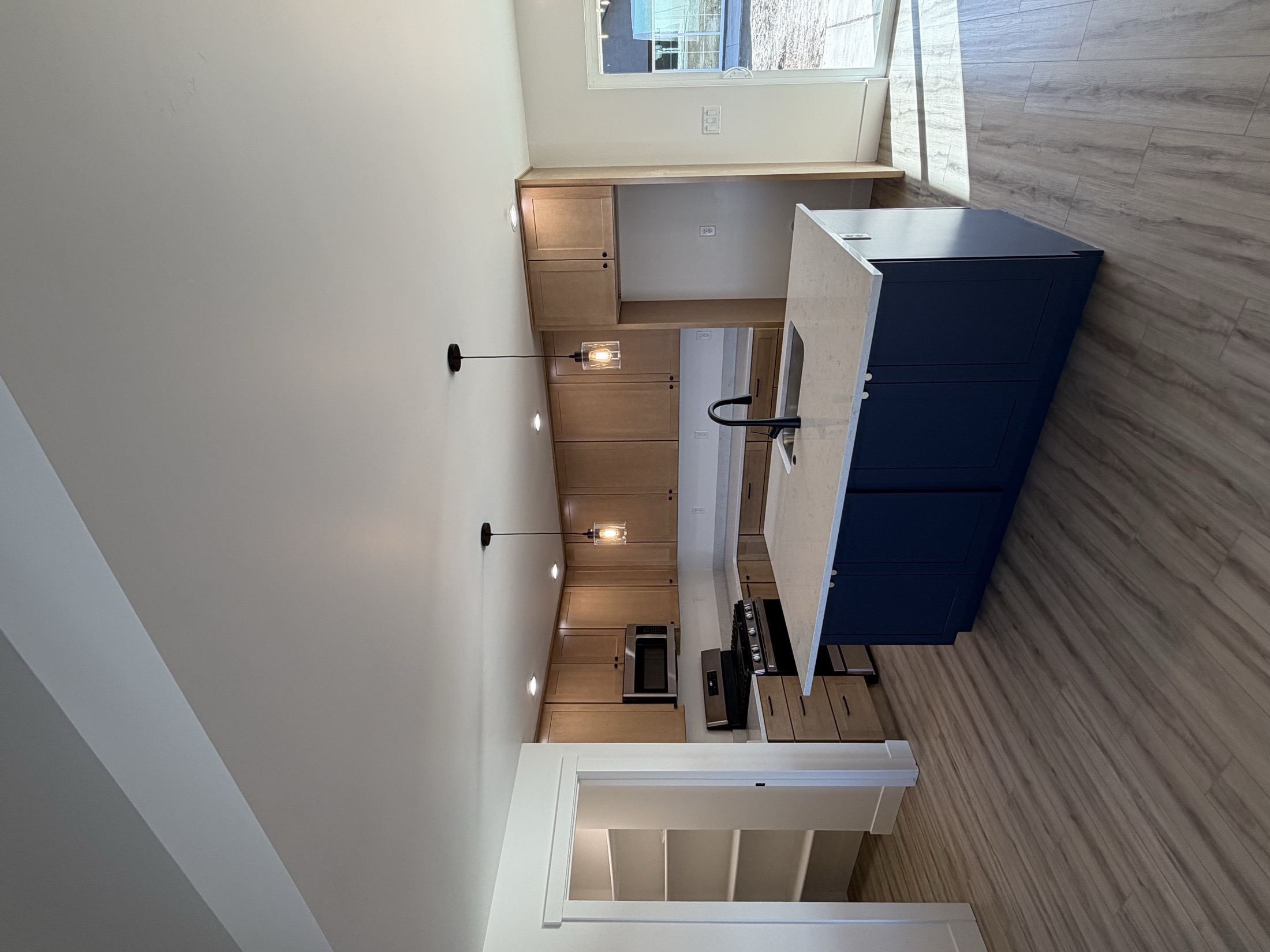Custom Idaho kitchen with navy lower cabinets and natural wood uppers