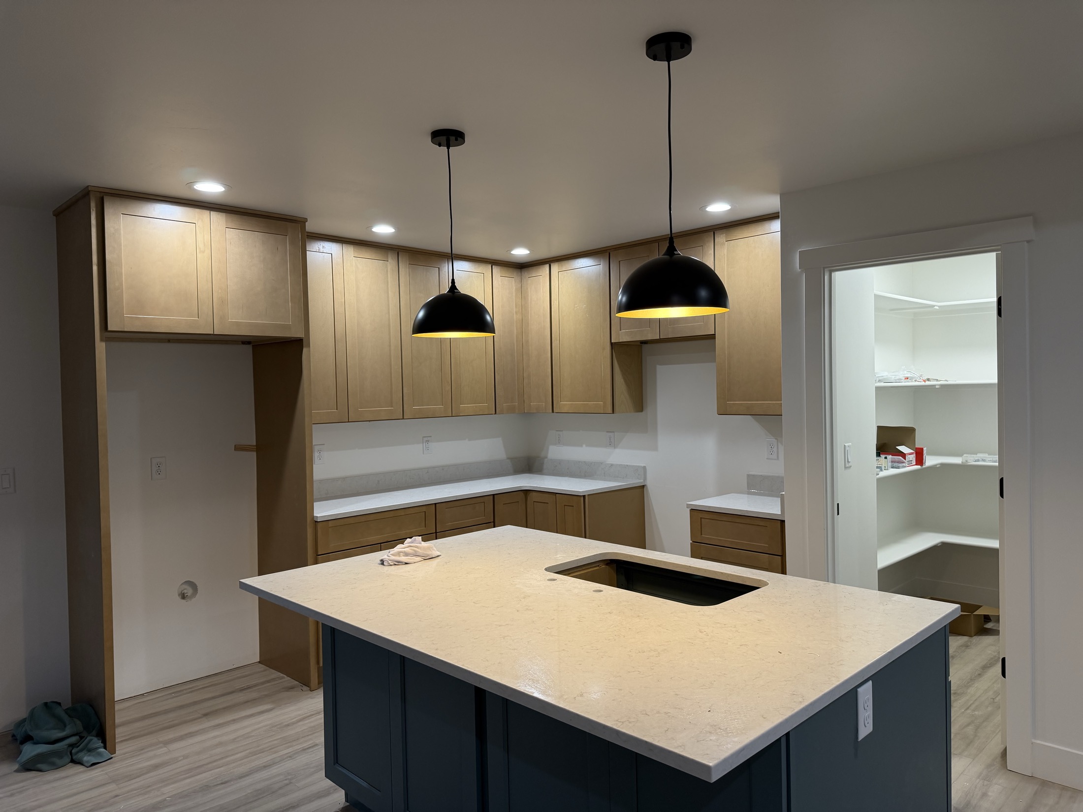 Kitchen with pendant lights, pantry door, and stone counters