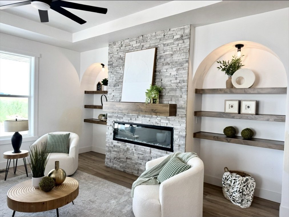 Living room with stacked stone fireplace and arched built-in shelving